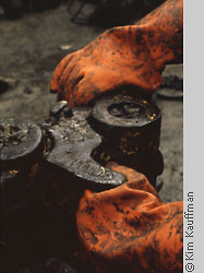 Industrial photo of oil rig detail and orange gloved hands by corporate photographer kim kauffman
